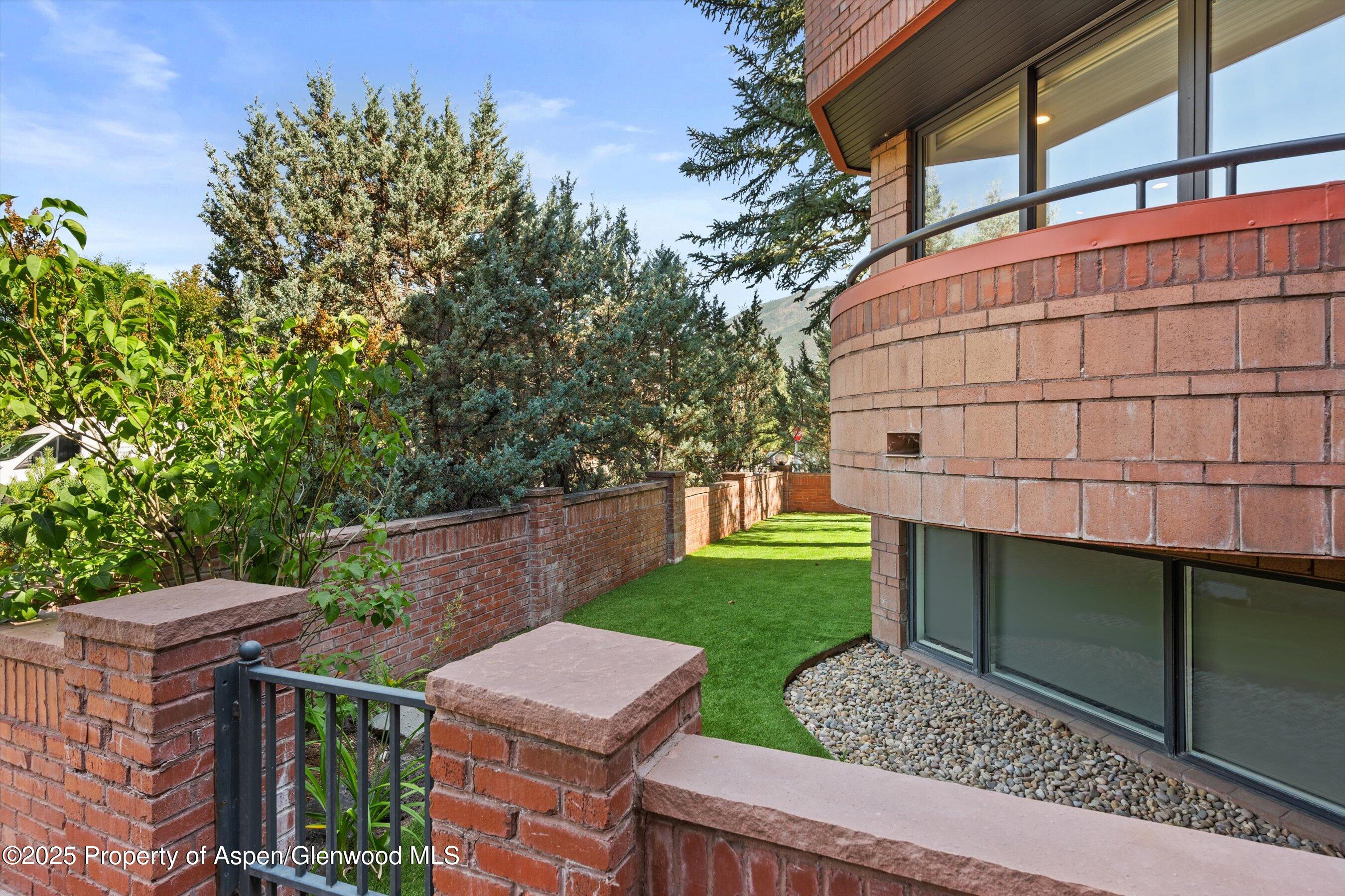 208 South Spring Street, Unit 1 Aspen, CO 81611 - Photo 28 of 29 a view of a chair and table in the backyard with wooden fence