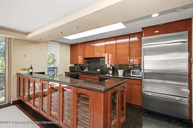 a kitchen with stainless steel appliances granite countertop a sink and a stove