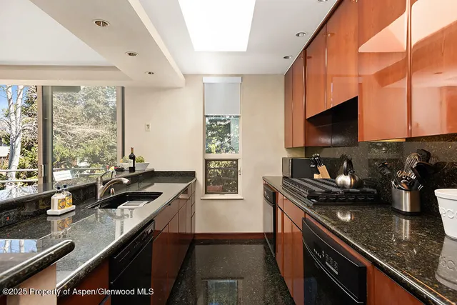 a kitchen with granite countertop a sink and a stove top oven