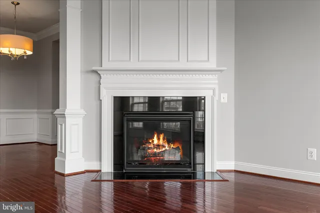 a living room with wooden floor and a fireplace