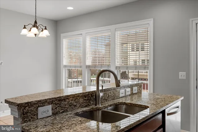 a kitchen with a granite countertop sink and a window