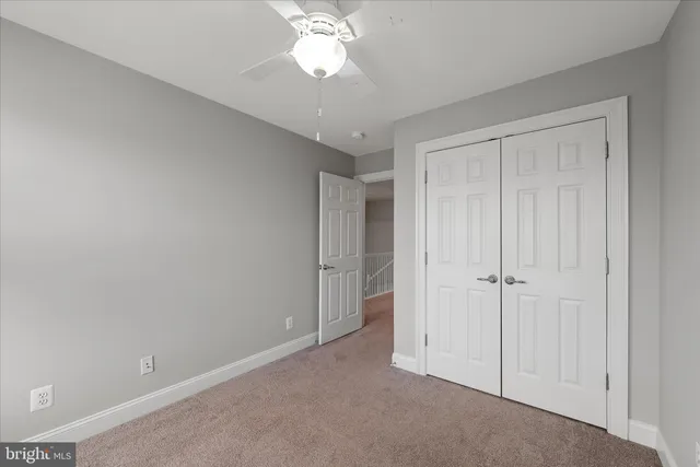 an empty room with a chandelier fan