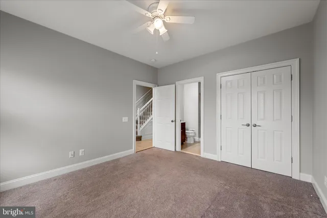 a view of a room with a ceiling fan and entryway