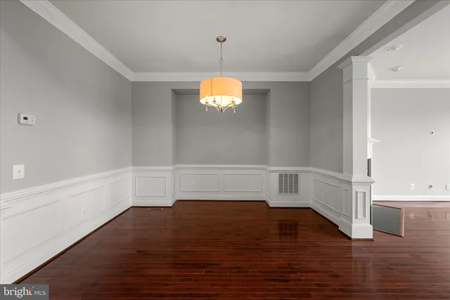 a view of empty room with wooden floor and window