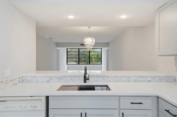 a view of a kitchen sink a window and stainless steel appliances