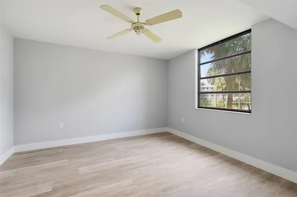 an empty room with a window and a fan