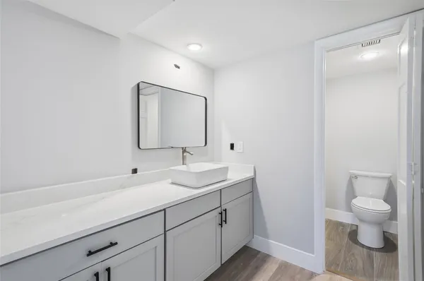 a bathroom with a toilet sink and mirror