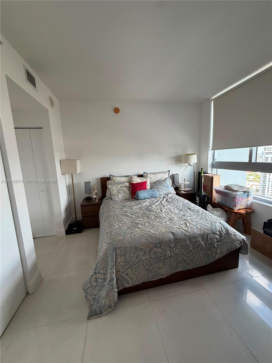 90 Southwest 3rd Street, Unit 4006 Miami, FL 33130 - Photo 14 of 19 a bedroom with a bed and a mirror
