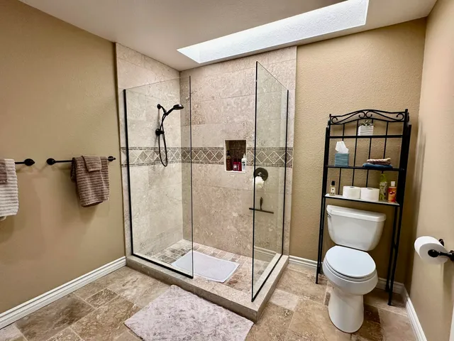 a bathroom with a toilet and a shower