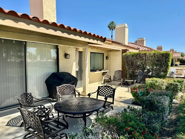 a view of a patio with table and chairs and potted plants