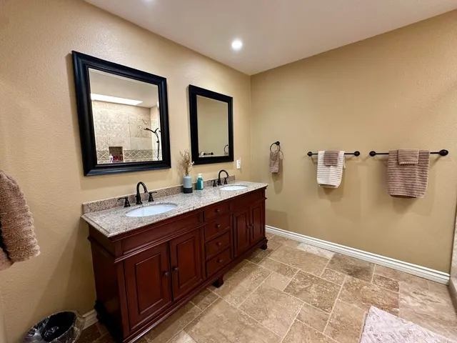 a bathroom with a double vanity sink and mirror