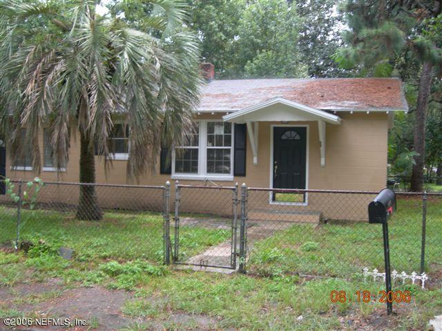 a view of a house with backyard and a tree