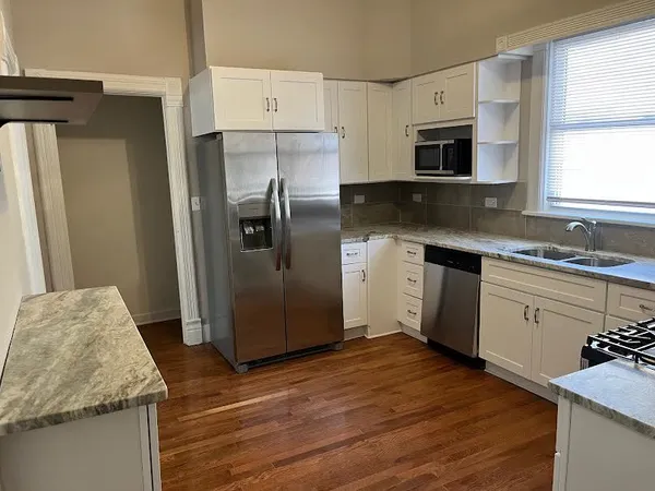 a kitchen with stainless steel appliances granite countertop a refrigerator sink and stove