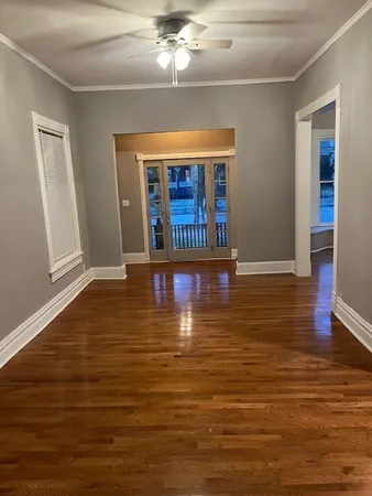 a view of an empty room with window and wooden floor