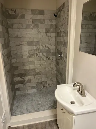 a bathroom with a sink a shower and a mirror