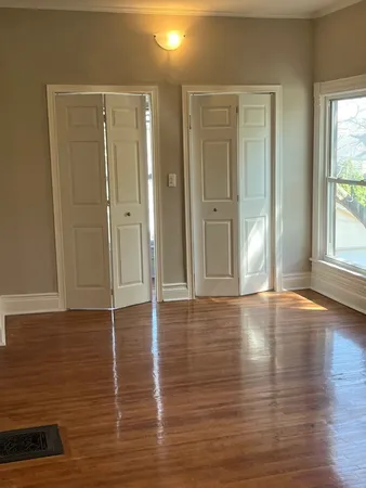 a view of a livingroom with wooden floor and window