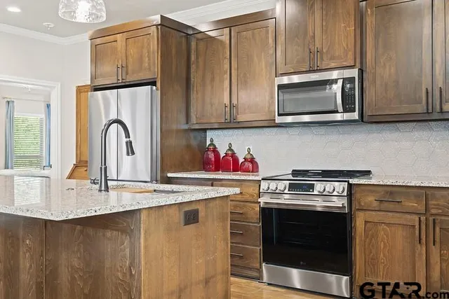a kitchen with granite countertop a stove top oven microwave and cabinets
