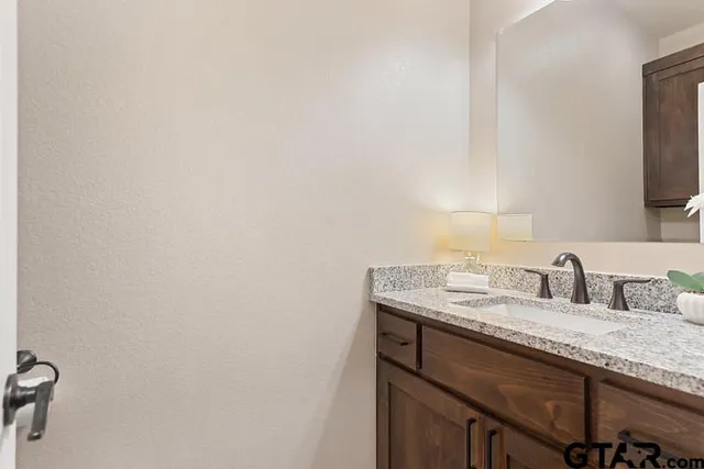 a bathroom with a granite countertop sink and a mirror