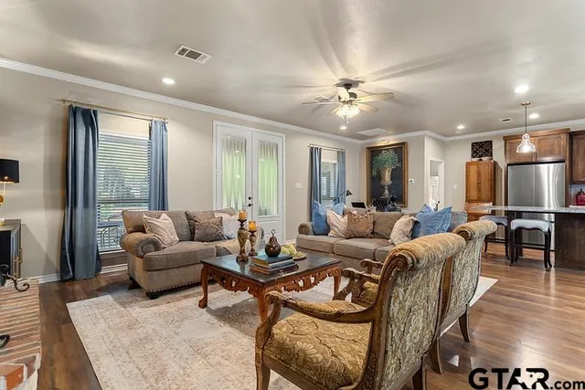 a living room with furniture ceiling fan and a rug