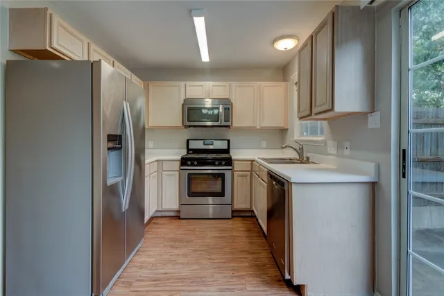 a kitchen with stainless steel appliances a refrigerator sink and microwave