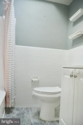 a white toilet sitting next to a shower