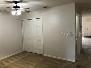 an empty room that has a light fixture and a fan