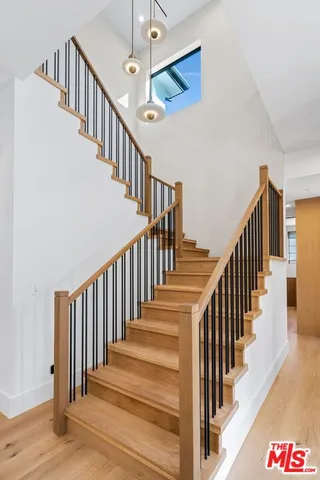 a view of staircase with lots of frames on wall and wooden floor