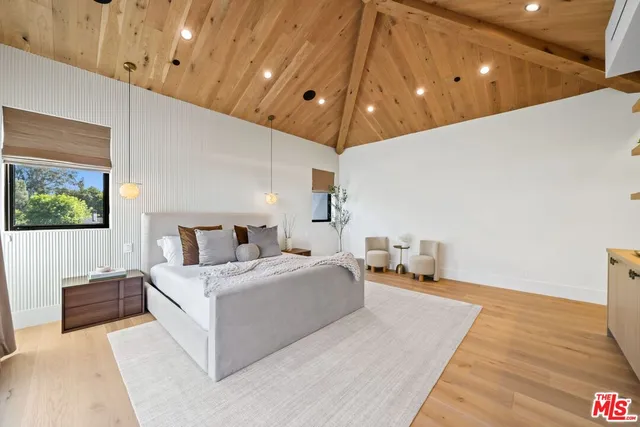 a spacious bedroom with a large bed and a chandelier