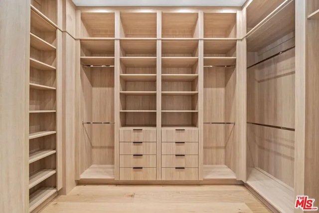 a view of walk in closet with empty racks