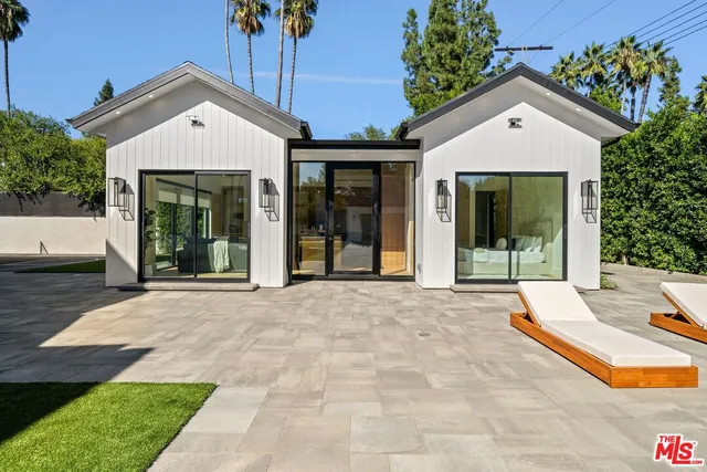 a front view of a house with a yard and potted plants
