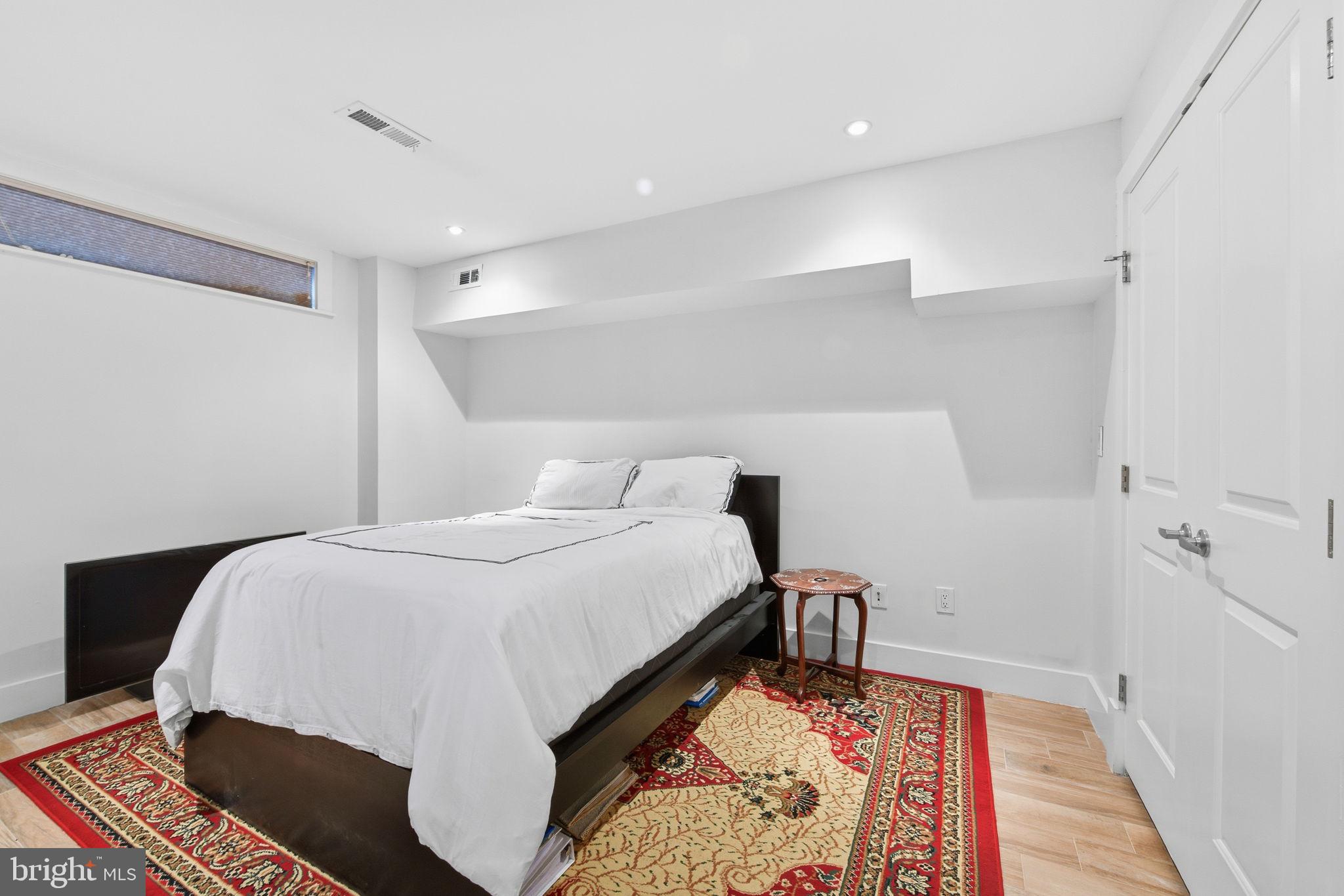 26 Q Street Northeast, Unit 1 Washington, DC 20002 - Photo 27 of 36 a bed room with a bed and a lamp