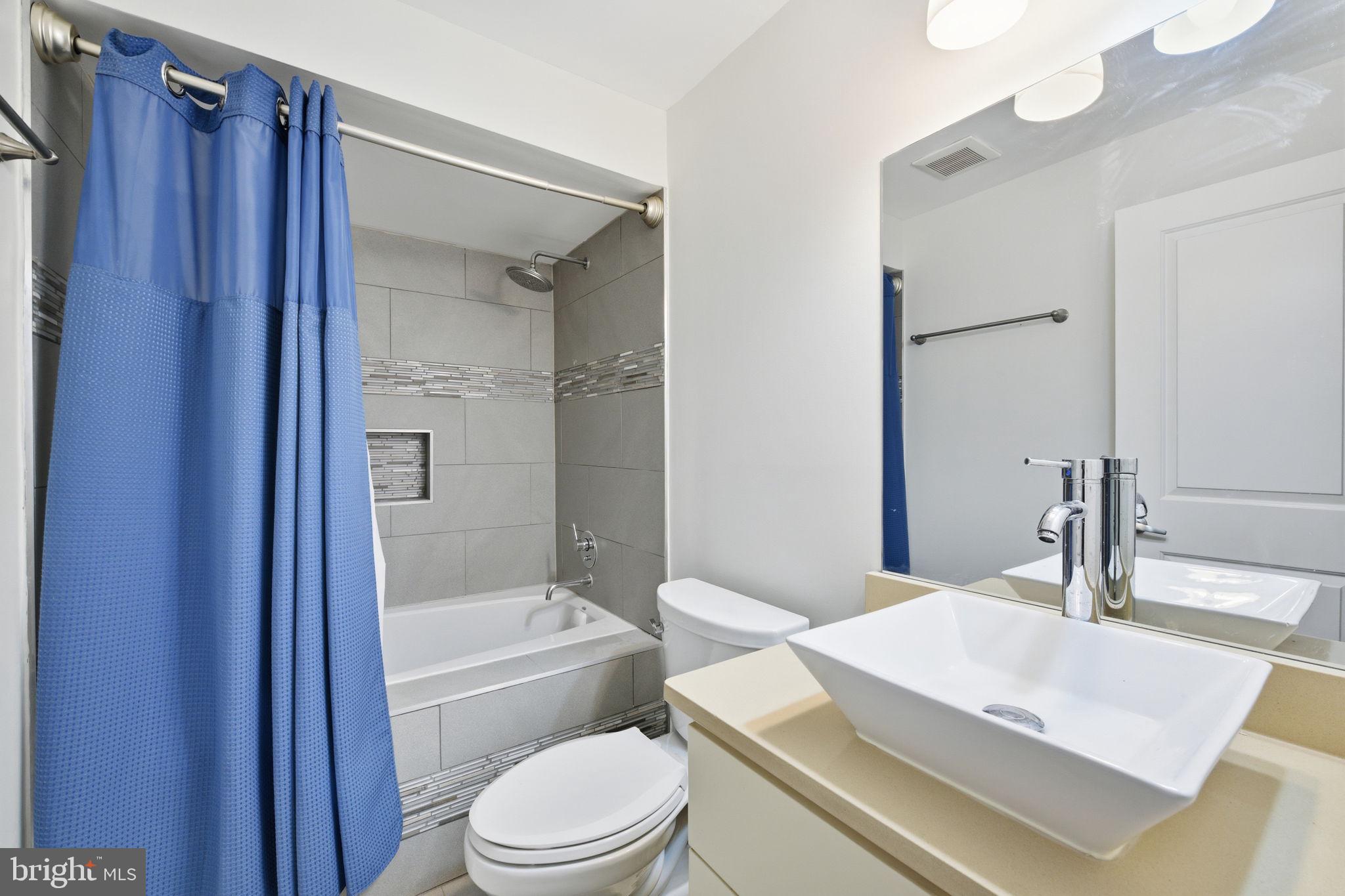 26 Q Street Northeast, Unit 1 Washington, DC 20002 - Photo 29 of 36 a bathroom with a sink a toilet a mirror and shower