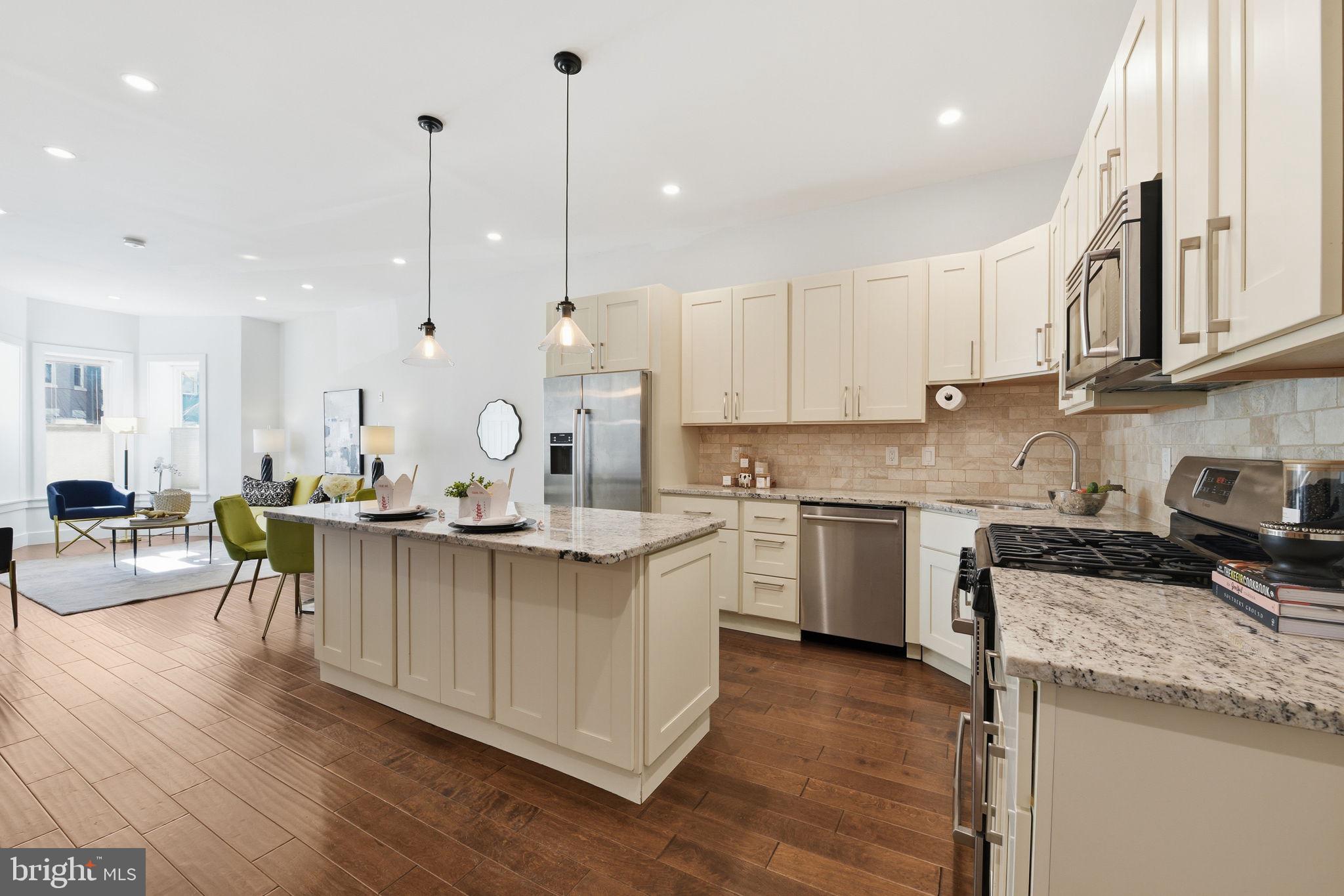 26 Q Street Northeast, Unit 1 Washington, DC 20002 - Photo 10 of 36 a kitchen with stainless steel appliances granite countertop a stove a sink dishwasher a refrigerator and white cabinets with wooden floor