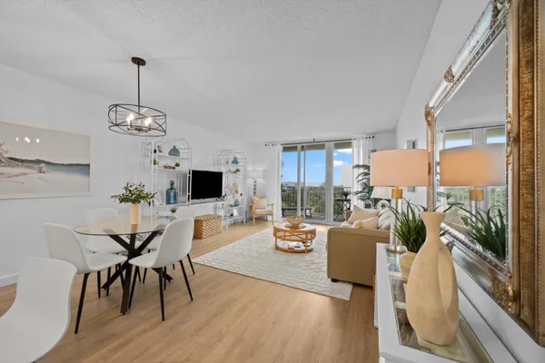 a living room with furniture a dining table and a floor to ceiling window