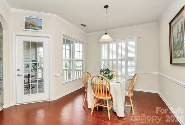 a view of a dining room with furniture a chandelier and wooden floor