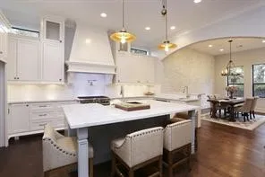 a kitchen with a sink a stove a dining table and chairs