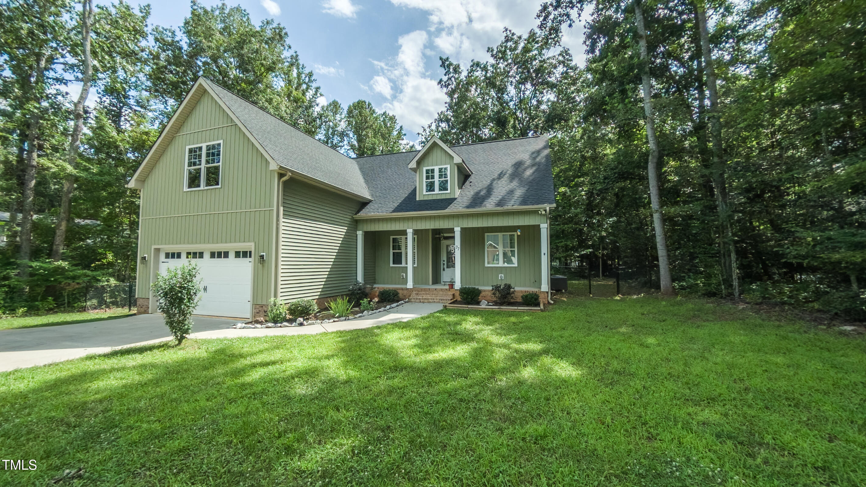 77 Running Deer Path Timberlake, NC 27583 - Photo 2 of 41 a front view of a house with a yard and trees
