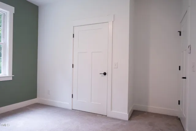 a large bed sitting in a bedroom next to a window