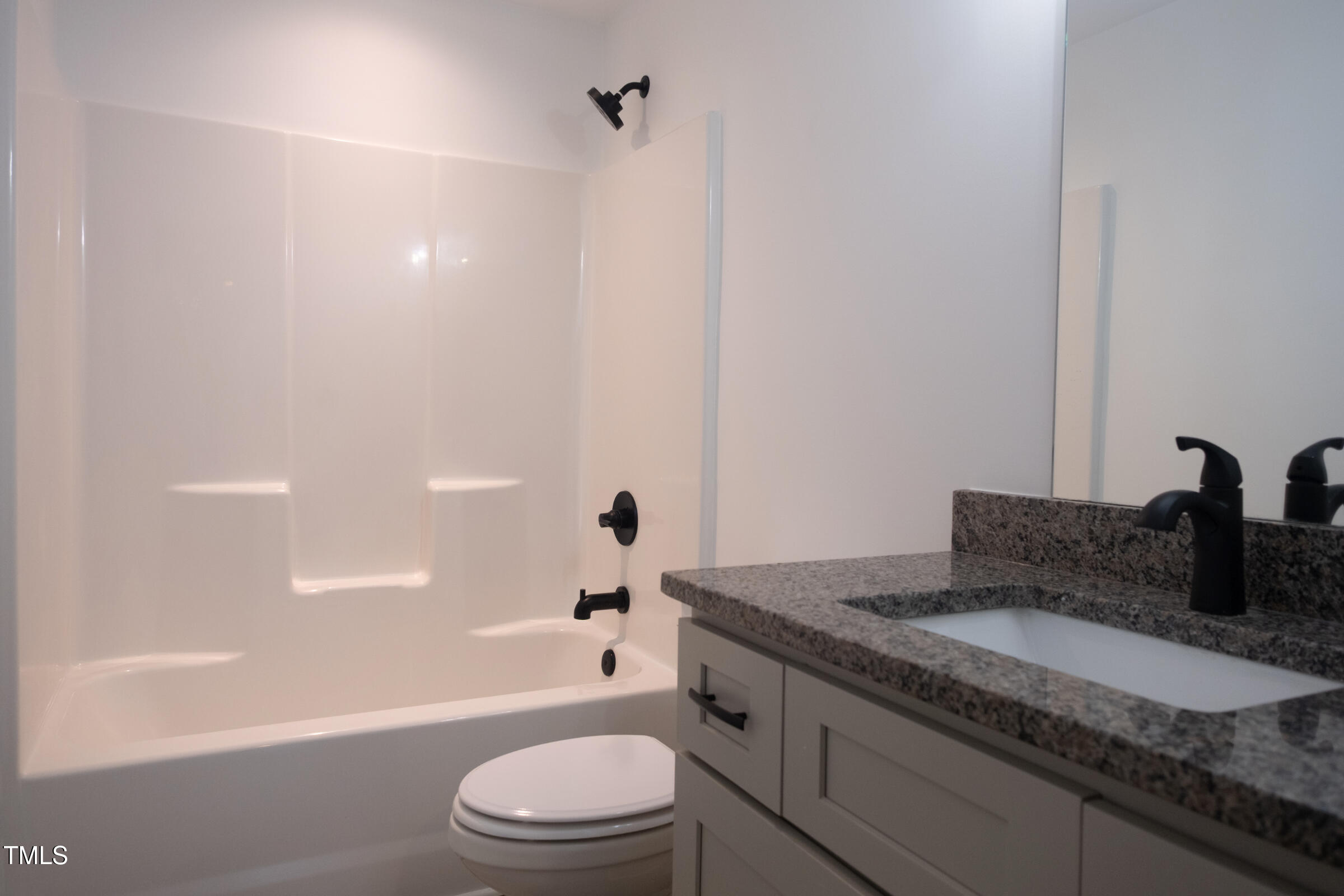 77 Running Deer Path Timberlake, NC 27583 - Photo 36 of 41 a bathroom with a granite countertop sink a toilet and bathtub