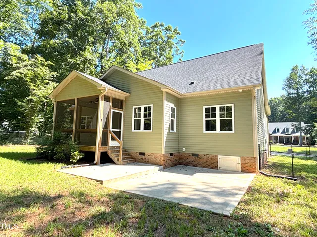 a front view of a house with a yard and trees