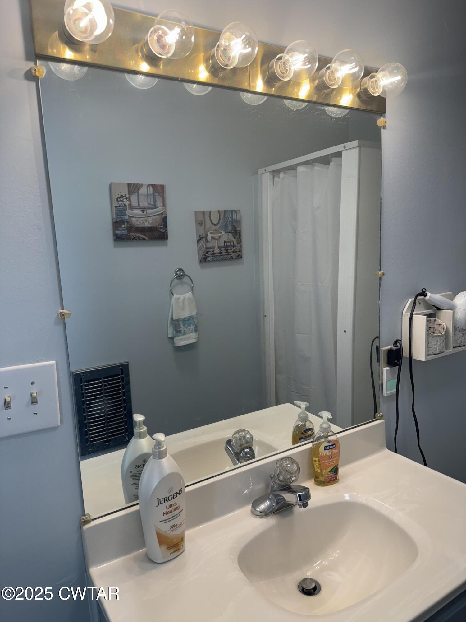 2685 Sunshine Road Henderson, TN 38340 - Photo 31 of 36 a bathroom with a sink and a mirror