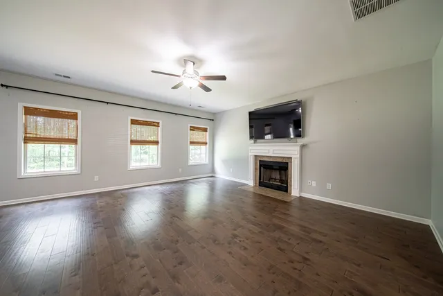 a view of a room with wooden floor staircase and a kitchen