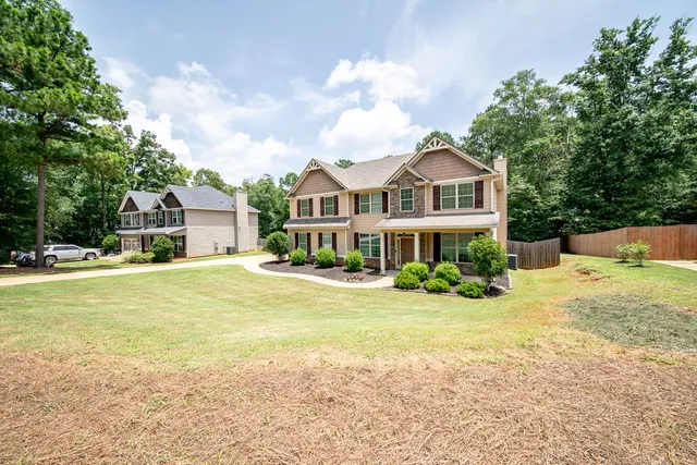 a front view of a house with swimming pool and porch with green space