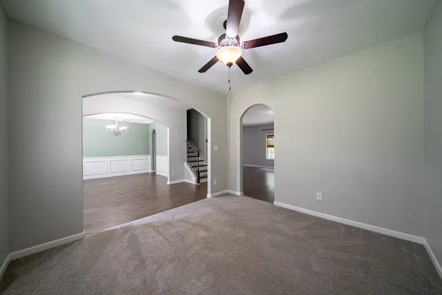 an empty room with stairs and wooden floor