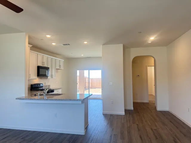 a living room with wooden floor and large windows
