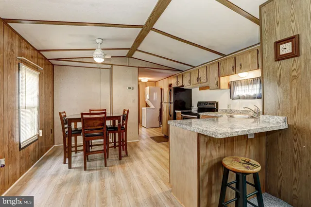 a kitchen with a table chairs refrigerator and cabinets