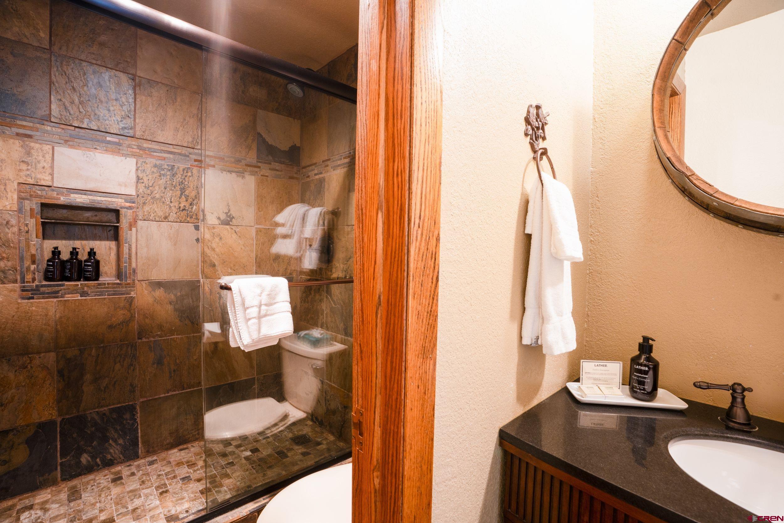 11 Snowmass Road, Unit 440 Crested Butte, CO 81225 - Photo 11 of 41 a bathroom with a granite countertop sink and a mirror