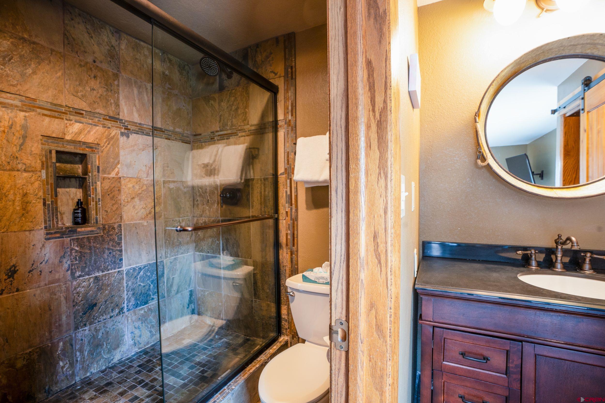 11 Snowmass Road, Unit 440 Crested Butte, CO 81225 - Photo 12 of 41 a bathroom with a granite countertop toilet sink and mirror