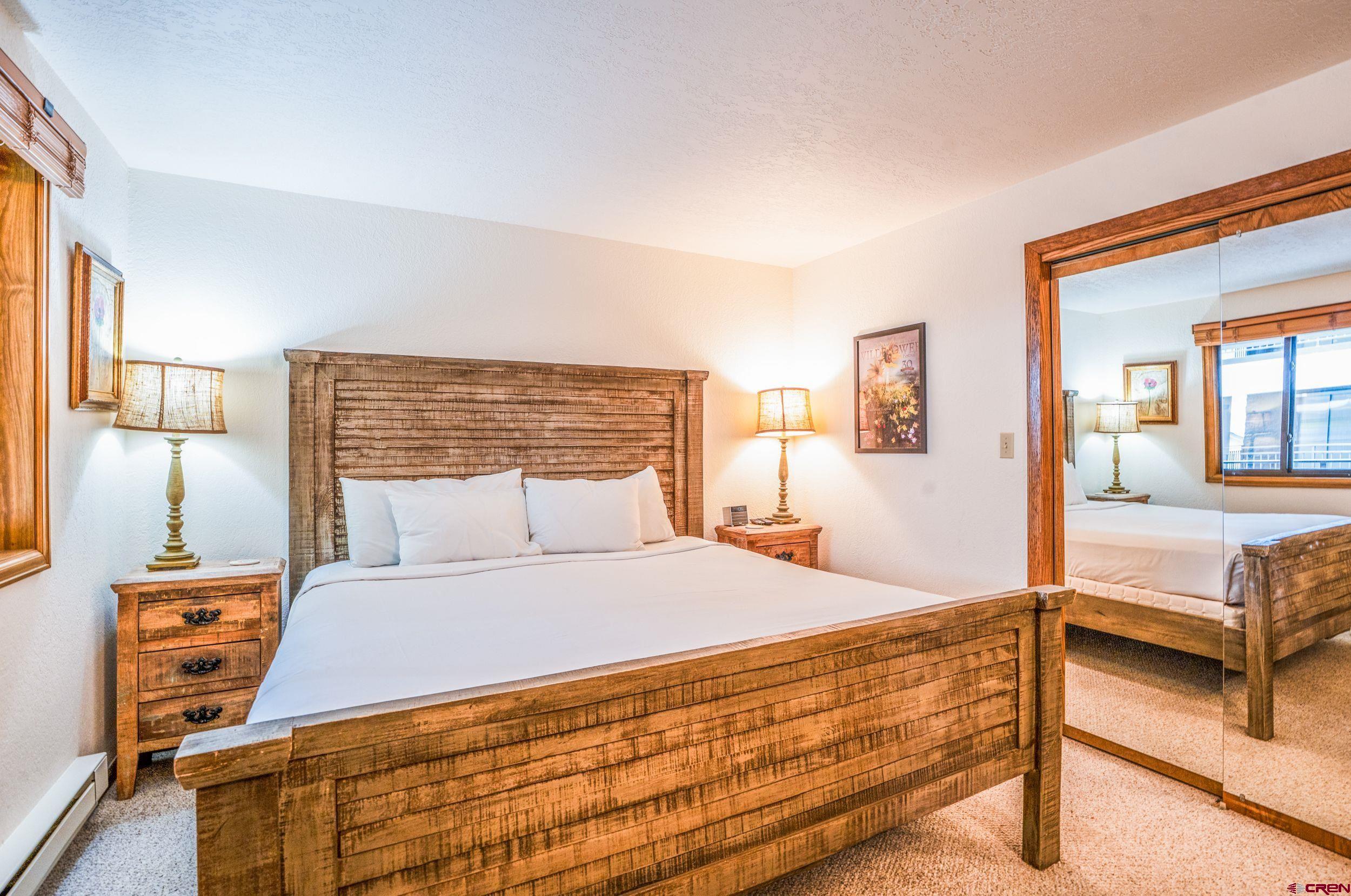 11 Snowmass Road, Unit 440 Crested Butte, CO 81225 - Photo 14 of 41 a bedroom with a bed and wooden floor