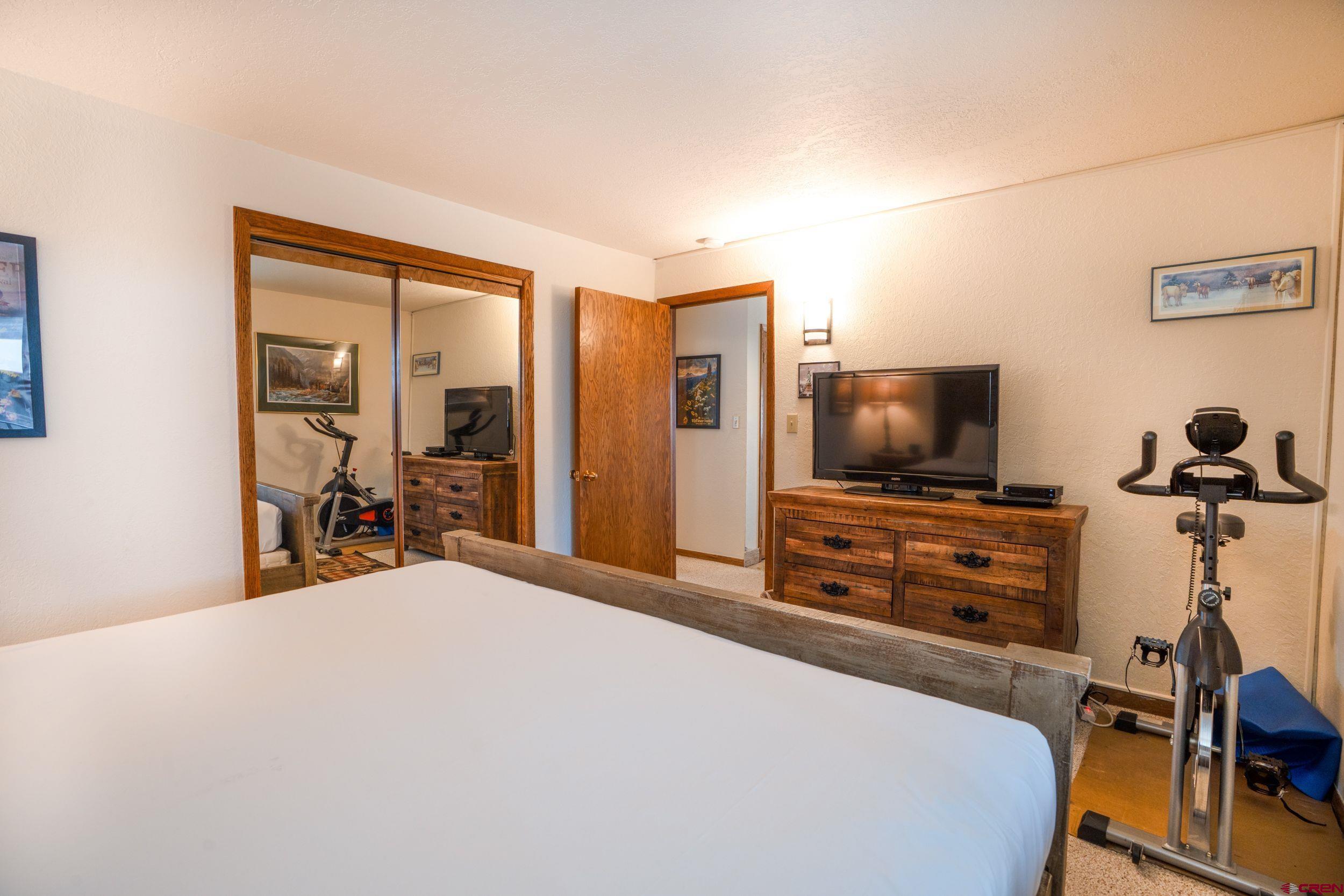 11 Snowmass Road, Unit 440 Crested Butte, CO 81225 - Photo 15 of 41 a bedroom with a bed and a flat screen tv